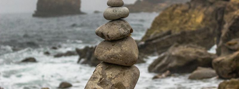 Stacked stones on a beach, symbolizing balance and stability.